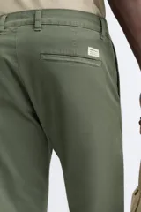 Pantalón chino azul marino, corte skinny fit, confeccionado en tejido de algodón con elasticidad. Cuenta con bolsillos frontales y traseros de vivo. Cierre frontal con cremallera y botón.