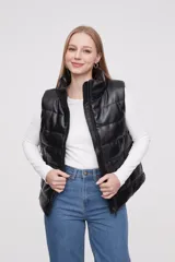 Chaleco negro sin mangas de material sintético, con diseño acolchado y corte recto.