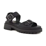 Sandalias bajas color beige con plataforma blanca y suela marrón. Presentan dos tiras anchas con hebillas metálicas plateadas.