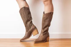 Botas de cuero color marrón con caña alta, punta fina y taco de madera.
