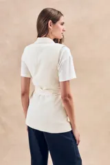 Chaleco negro con solapas, corte entallado y lazo para atar en la cintura.