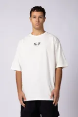 Remera blanca de corte oversize con estampado pequeño de dos caballos alados en el pecho.