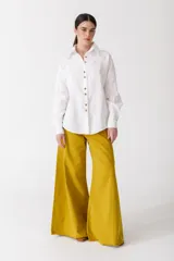 Camisa blanca de lino con botones de madera, corte recto y mangas largas.