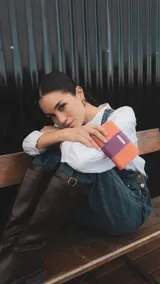Billetera mediana combinada en símil cuero color naranja y lila, con compartimento interior con tarjeteros y cierre interior. Monedero con cierre alrededor.