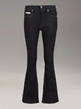 Pantalón de jean azul oscuro, de corte ajustado en la cadera y muslos, y acampanado a partir de la rodilla.