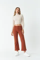 Pantalón acampanado color ladrillo de pana con bolsillos delanteros y traseros, tiro medio y presillas para cinturón.