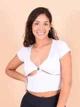Blusa blanca ajustada con diseño cropped y detalle de anillo en el centro.