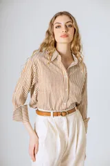 Camisa de manga larga con corte holgado y estampado de rayas verticales marrones sobre fondo blanco.