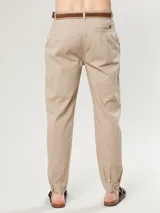 Pantalón de corte ajustado color gris, con pliegues frontales y bolsillos.