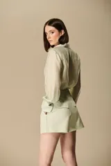 Camisa blanca de seda fluida, con silueta relajada, mangas largas con puño simple y cuello clásico.