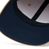 Gorra de béisbol Columbia color beige con paneles traseros de malla azul marino y logo de la marca bordado en el frente.