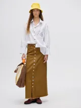 Falda midi de denim color marrón con hilado a la vista en el ruedo y abotonadura frontal.