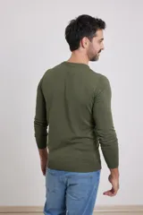 Sweater de escote a la base, color verde oscuro, hecho de 100% algodón y de corte ajustado.