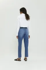 Pantalón de jean azul de corte amplio con botamanga ajustada, tiro alto y lavado stone wash con bigotes.