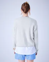 Sweater negro de cashmere cepillada con cuello en V, corte oversize, mangas largas y terminaciones acanaladas.
