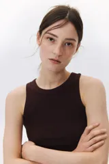 Musculosa marrón de punto de algodón acanalado, corte entallado, cuello redondo y ribete fino en escote y sisas.