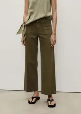 Pantalón de jeans color verde oliva, de corte wide leg, tiro alto y largo al tobillo. Presenta bolsillos de parche frontales y cierre con cremallera y botón.