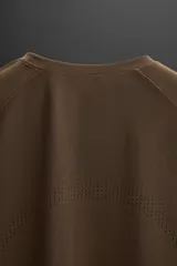 Camiseta deportiva marrón de tejido técnico, ligero y elástico con perforaciones. Cuello redondo, manga corta y logo estampado.