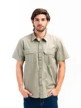 Camisa de manga corta color beige con cuello clásico, cierre frontal con botones, dos bolsillos con solapa abotonada en el pecho y corte recto. Ideal para actividades al aire libre.