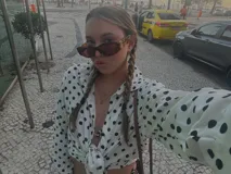 Camisa negra con estampado de lunares blancos, de manga larga y cuello clásico.
