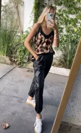 Pantalón babucha de cuerina color negro, con bolsillos laterales y cinturón.