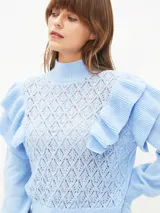 Sweater lila de tejido calado con cuello alto y mangas largas abullonadas con volados.