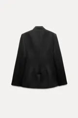 Blazer negro con cuello solapa de muescas y manga larga. Tiene falsos bolsillos de vivo en el delantero, forro interior a tono y cierre frontal cruzado con botón a presión.
