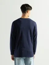 Remera negra de manga larga con cuello redondo, confeccionada en tejido mini piqué de algodón.