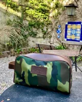 Neceser de lona verde con detalles en cuero color beige y etiqueta con logo de la marca Sierra Mora.