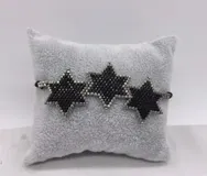 Pulsera tejida con cuentas doradas y azul oscuro, con tres dijes en forma de estrella.