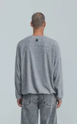 Sweater gris de corte holgado, cuello redondo y puños ajustados.
