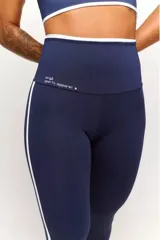 Calza deportiva azul marino con cintura alta y detalles en blanco en cintura y laterales.
