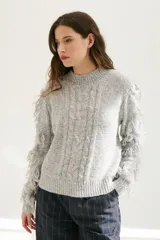 Sweater color arena de tejido de punto con cuello redondo y mangas largas con flecos.
