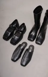 Zapato guillermina de cuero negro con punta cuadrada, tira sobre el empeine y suela track.