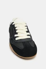 Zapatillas deportivas negras con detalle de estampado animal en la parte trasera, suela color caramelo y ajuste con cordones.