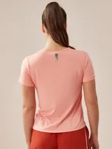 Remera de poliéster color coral, de corte clásico y mangas cortas.