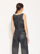 Top estilo corset confeccionado en tejido 100% algodón con proceso de coating simil cuero en tono azulado. Presenta desgastes estratégicos que dejan entrever la base natural, aportando contraste y textura.