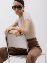 Top de punto color beige, con cuello redondo y mangas cortas.