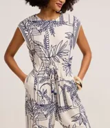 Mono sin mangas confeccionado en viscosa texturizada, con cuello redondo, sisas rayadas, lazo en la cintura y bordados de follaje con paisaje arquitectónico.