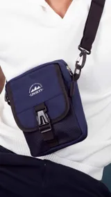 Morral verde militar con cierre, bolsillo delantero con presilla y broche de plástico, bolsillos internos y correa larga regulable.