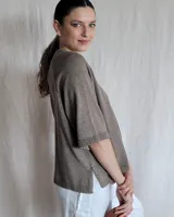 Sweater color beige de tejido de punto con mangas cortas y cuello redondo.