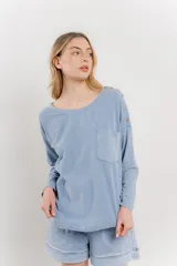 Remera celeste de manga larga con cuello redondo y bolsillo en el pecho.