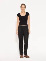 Remera negra ajustada al cuerpo, de mangas cortas y escote redondo amplio.