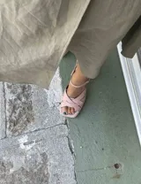 Sandalias color rosa pálido con tiras cruzadas y cierre con hebilla en el tobillo.