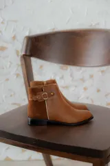 Bota clásica de cuero negro, baja, con detalles en metal y diseño cómodo para uso prolongado.