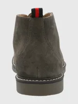 Botín acordonado de gamuza color marrón, con suela de goma y plantilla de cuero.