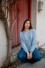 Camisa celeste con volados en cuello y en la parte delantera, con cordones.