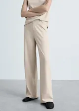 Pantalón de punto color beige, de corte wide leg, tiro medio y cintura elástica.