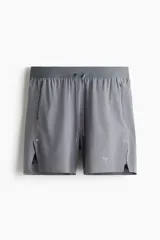 Short deportivo gris con perforaciones, de corte estándar, con cintura elástica con cordón de ajuste, bolsillos laterales con cierre, aberturas laterales y logo estampado. Incluye calza biker interior con bolsillo para celular.