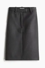 Pollera gris oscuro de corte recto hasta la rodilla, con tajo trasero, tiro alto, pretina prolongada, cierre de corchete oculto y bolsillo trasero decorativo. Sin forrar.